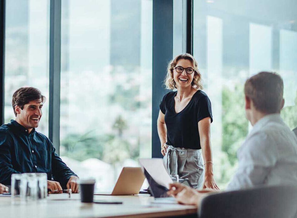 A businesswoman smiling whilst talking to colleagues