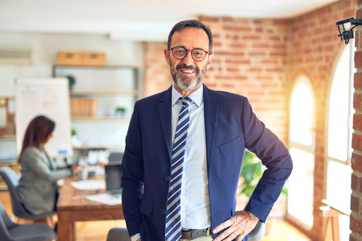 A businessman facing directly into the camera and smiling