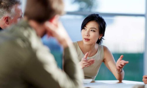 A woman discussing with her peers